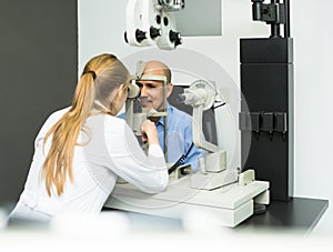 Female ophthalmologist and mature patient checking eyesight in c