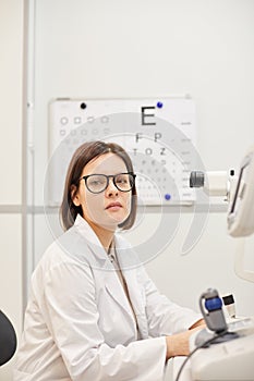 Female Ophthalmologist Posing by Machines in Clinic