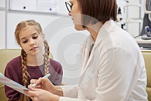 Female Ophthalmologist Talking to Little Girl