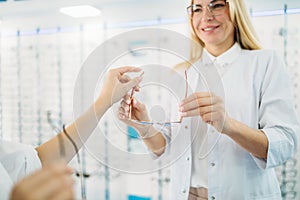 Female optician and customer shooses glasses