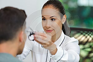 Female optician placing testing frames onto male patient