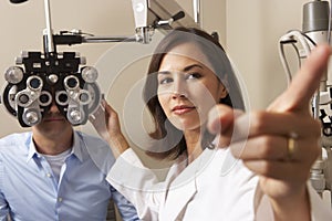 Female Optician In Surgery Giving Man Eye Test photo