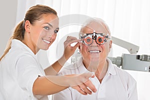 Female Optometrist Checking Patient`s Vision With Trial Frame