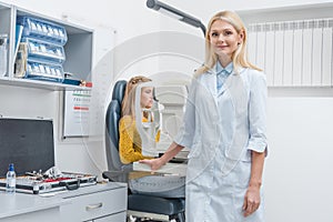 female optometrist examining patient through slit lamp