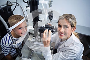 Female optometrist examining young patient on slit lamp