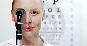 Female optometrist holding ophthalmoscope