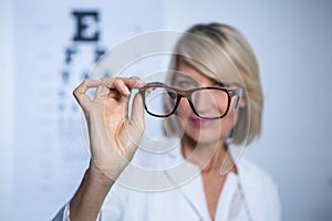 Female optometrist holding spectacles