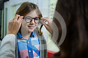 Female optometrist prescribing spectacles to young patient