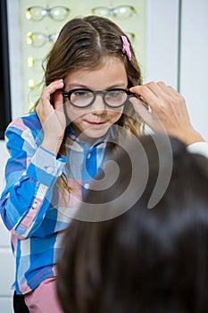 Female optometrist prescribing spectacles to young patient