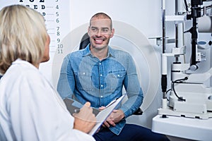 Female optometrist talking to male patient