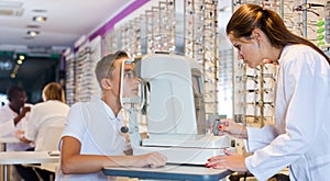 Female optometrist testing eyesight of boy