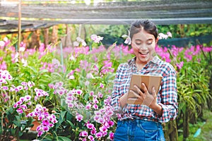 Female Orchid Garden Owner in Thailand Hold a tape to send information on the Internet.