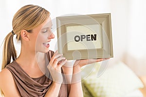 Female Owner Holding Open Sign In Bedding Store