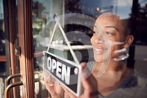 Female Owner Of Start Up Coffee Shop Or Restaurant Turning Round Open Sign On Door photo