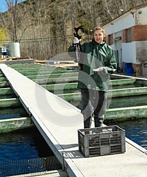 Female owner of sturgeon farm showing fish