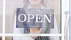 Female owner turning sign board to open coffee shop smile and happiness. Smiling asian woman open food and beverage cafe ready to