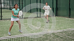 Female paddle tennis player during couple match at court