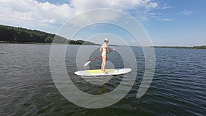Female paddling a board on a lake