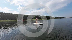 Female paddling a board on a lake