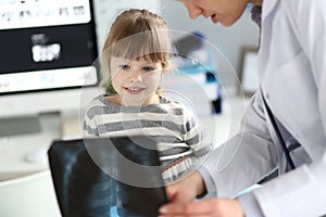 Female paediatrician working with cute little girl at her office explaining diagnosis