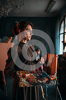 Female painter with brush and palette in hands