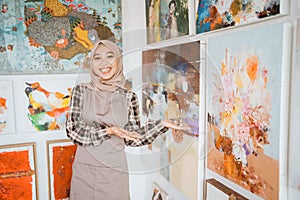 female painting artist showing and presenting her work