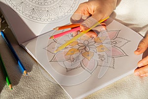 Female painting mandalas antistress page to combat stress. Relaxing hobby mental wellbeing and art therapy. Woman paints