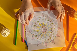 Female painting mandalas antistress page to combat stress. Relaxing hobby mental wellbeing and art therapy. Woman paints