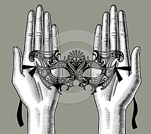 Female palms of hands with a decorative carnival Venetian mask photo