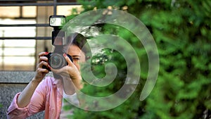 Female paparazzi hiding behind trees taking photos, searching for sensation