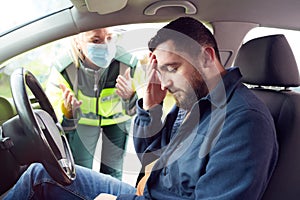 Female Paramedic Helping Male Driver With Whiplash Neck Injury Involved In Road Traffic Accident
