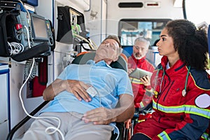 Female paramedic monitoring the patient heart rate using medical equipment