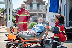 Female paramedic providing emergency medical care to an unconscious patient