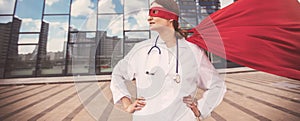 Female paramedic in a superhero raincoat standing on a city street.