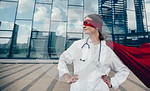 female paramedic in a superhero raincoat standing on a city street.