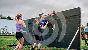 Female participants in obstacle course climbing wall