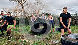 Female participants in an obstacle course turning a wheel