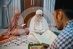 female participants reciting the Quran following the male recitation leader