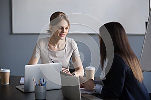 Female partners negotiating about future projects in office