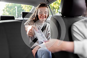 female passenger giving money to taxi car driver