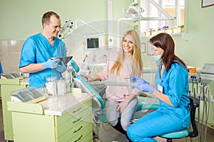 Female patien with two doctors at the dental office
