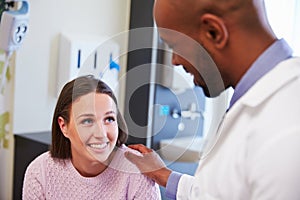 Female Patient Being Reassured By Doctor In Hospital Room photo