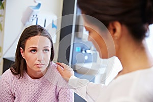 Female Patient Being Reassured By Doctor In Hospital Room photo