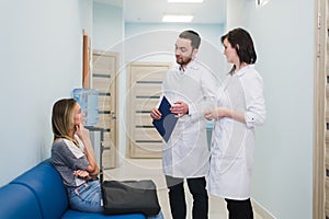 Female Patient Being Reassured By Doctors In Hospital Room