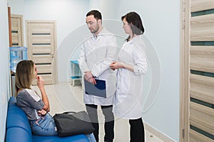 Female Patient Being Reassured By Doctors In Hospital Room