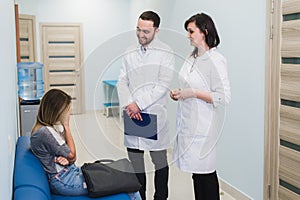Female Patient Being Reassured By Doctors In Hospital Room