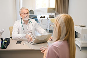 Female patient consulting with medical specialist in clinic office