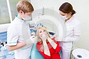Female patient in dentist office afraid of doctor, procedure