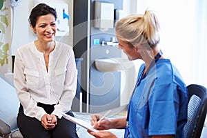 Female Patient And Doctor Have Consultation In Hospital Room