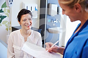 Female Patient And Doctor Have Consultation In Hospital Room